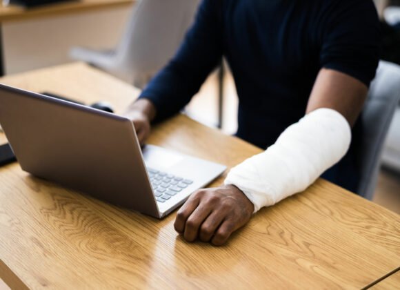 injured worker on a laptop with Worker's Compensation Insurance in Jersey City, Dumbo, NY, Bushwick, Prospect Park, NY, Brooklyn, Williamsburg, NY and Surrounding Areas